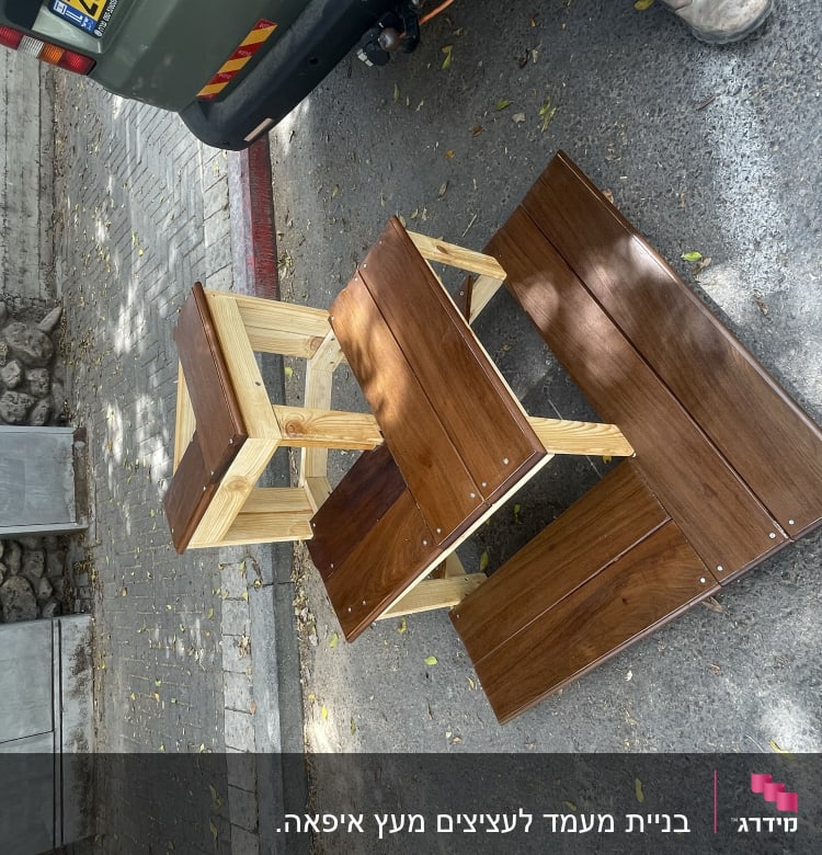 שולחן עץ עם ספסלים ברחוב ליד רכב